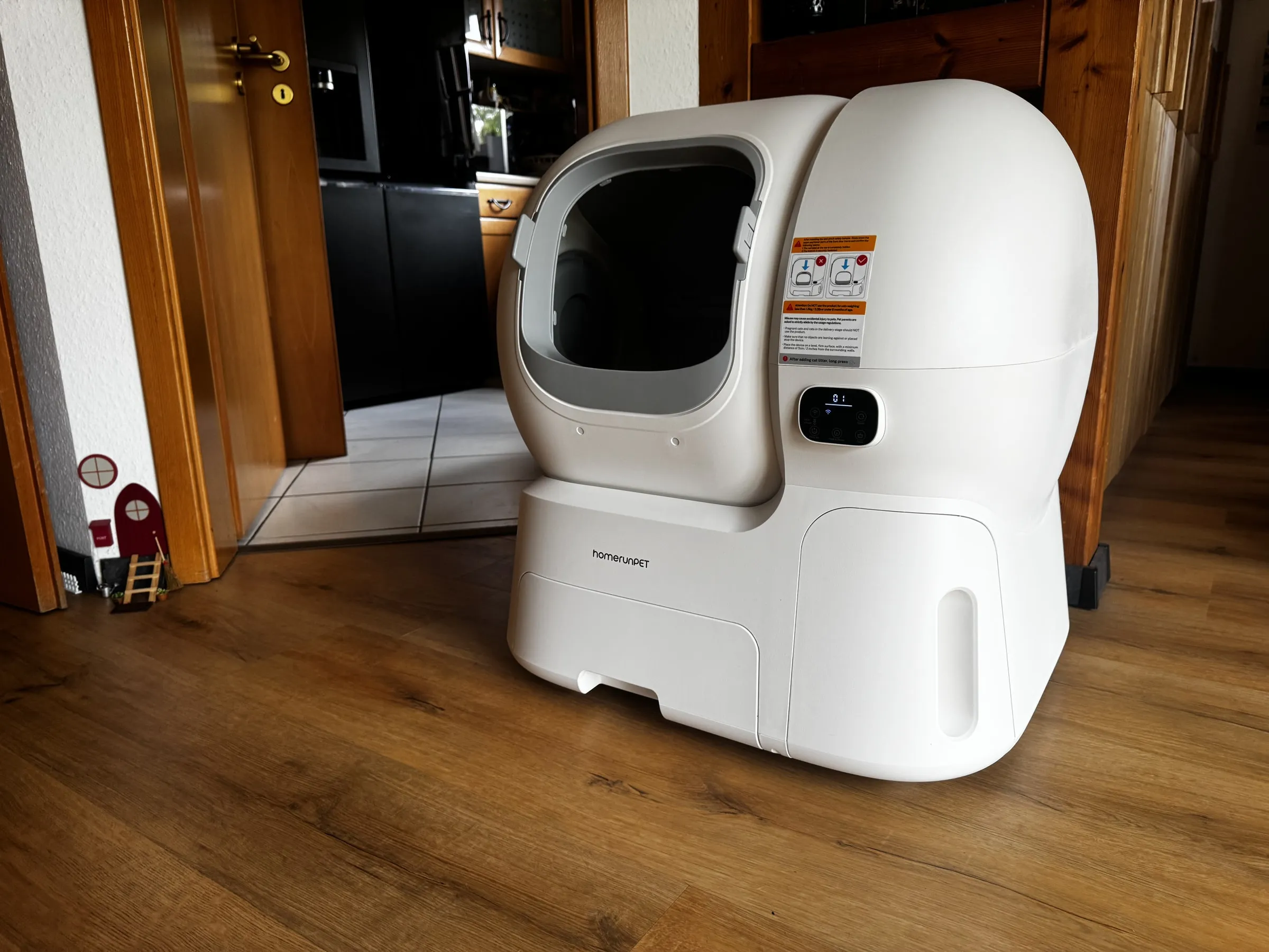 homerunPET CS106 self-cleaning litter box set up in a home hallway, showing its full body size and front entry
