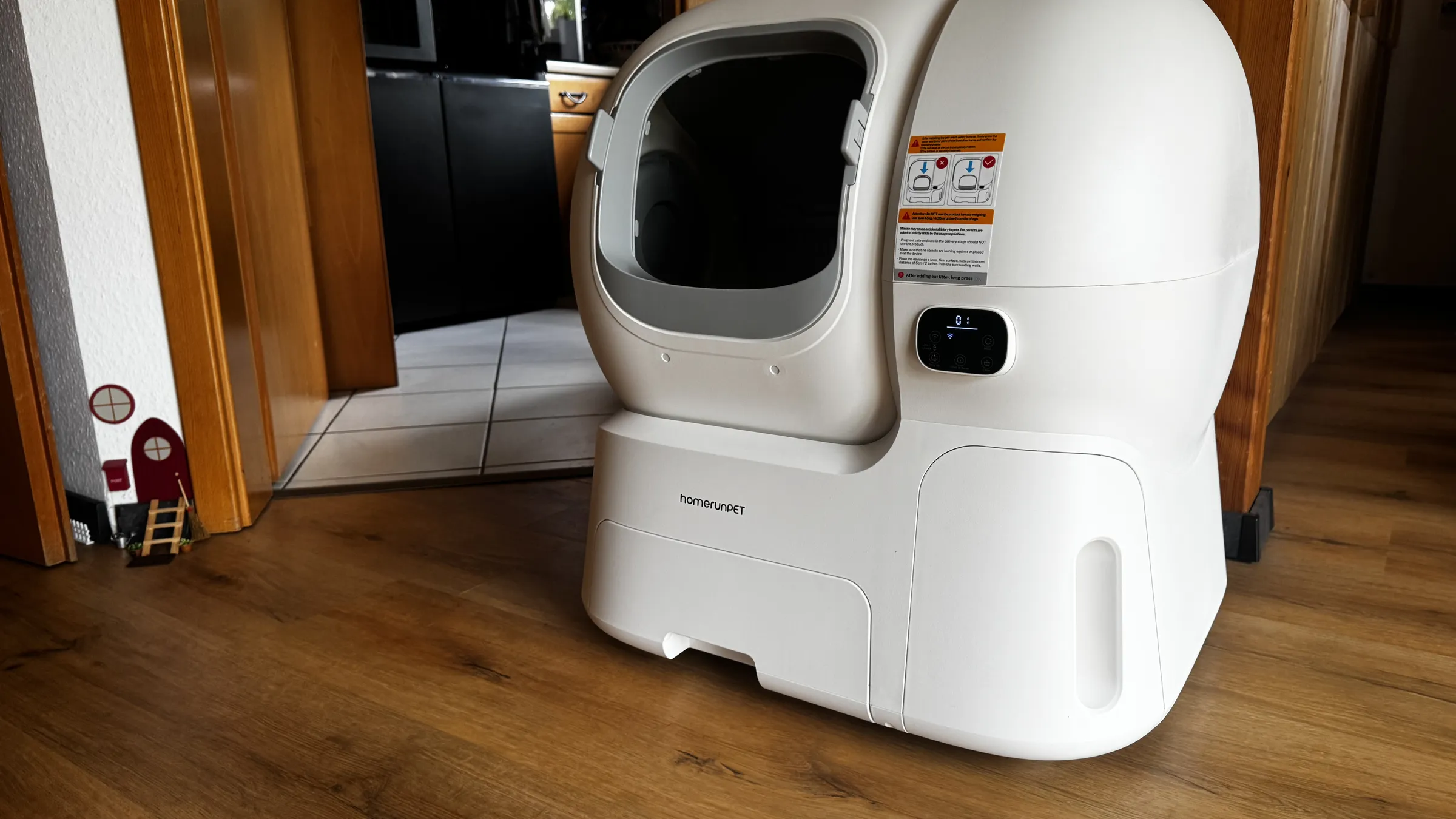 homerunPET CS106 self-cleaning litter box set up in a home hallway with the front entry visible